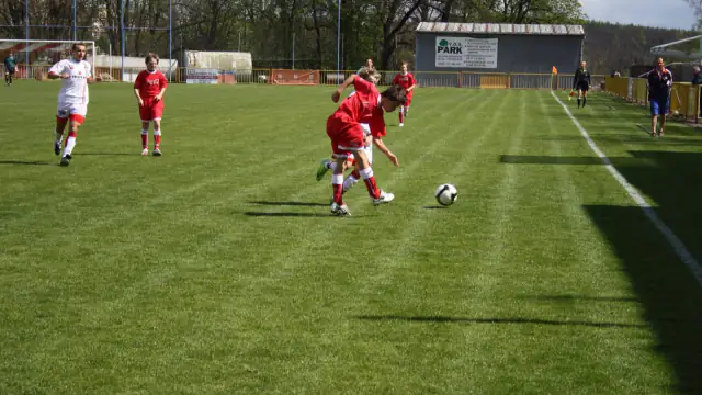 Jovens futebolistas de uma equipa de juniores a disputar a bola durante um jogo num relvado
